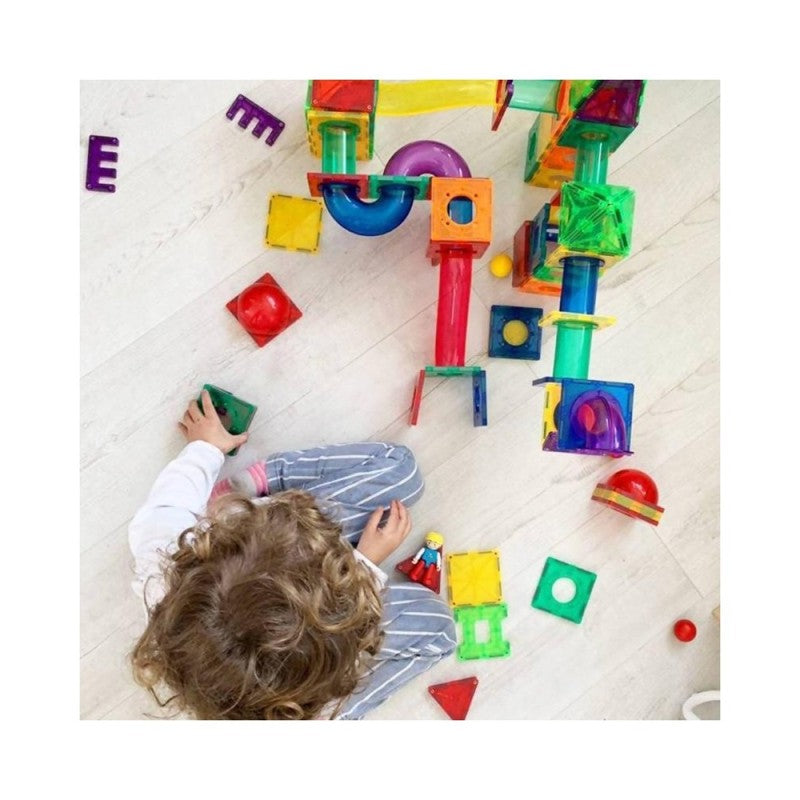Estrutura montada do BRAINTOYS IMANIX Slide com blocos magnéticos e pistas curvas translúcidas para bolas, em fundo branco.