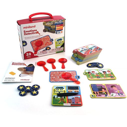 Jogo Miniland Emoti Detective completo com caixa, três lupas vermelhas, cartas de cenários com crianças, fichas estrela azuis e guia de atividades, tudo disposto sobre fundo branco.