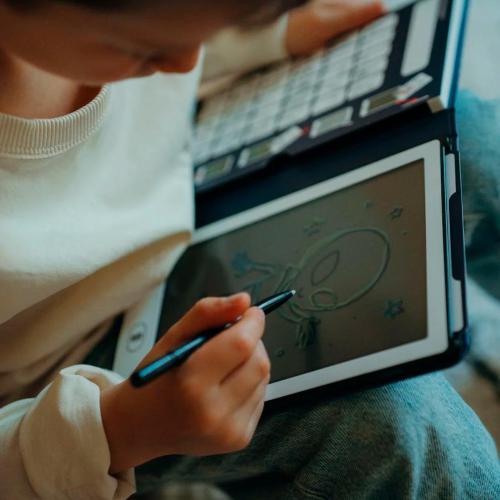 Criança a desenhar um alienígena no ecrã LCD do Tablet KidyWolf Galáxia com a caneta.