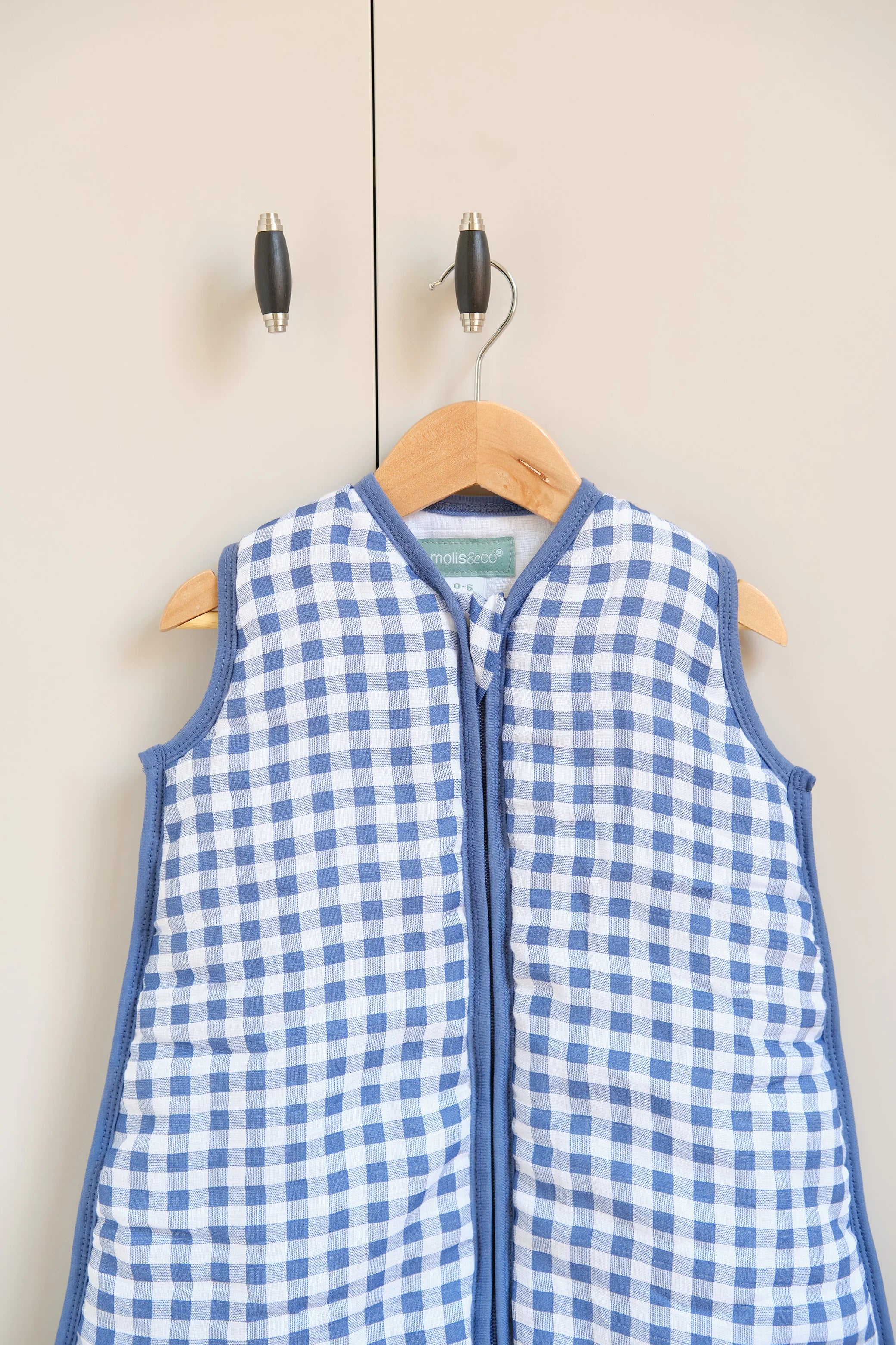 Detalhe do decote e fecho do saco de dormir MolisandCo TOG 2.5 em cotton muslin com padrão xadrez azul.