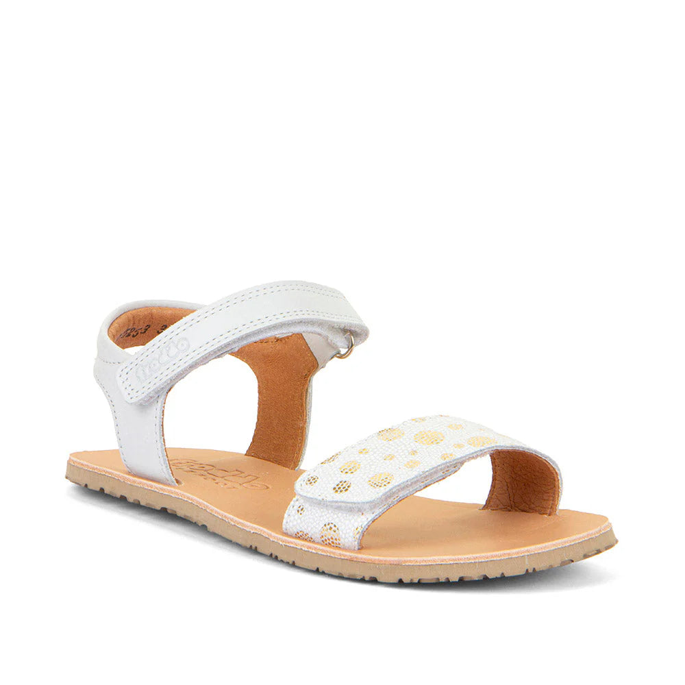 Sandália barefoot Froddo Flexy Lia em pele branca, com pormenores dourados perfurados na tira frontal e fecho ajustável em velcro. Sola ultraflexível e design minimalista para um calçado respeitador.