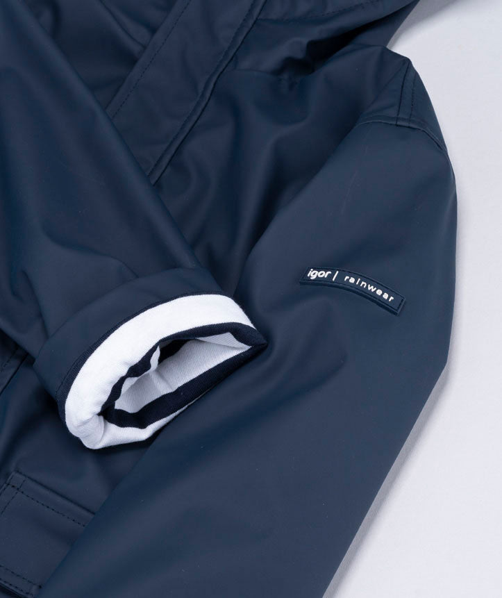 Detalhe da manga do casaco Igor impermeável marinho, mostrando o punho dobrado com forro às riscas e a etiqueta "igor | rainwear".