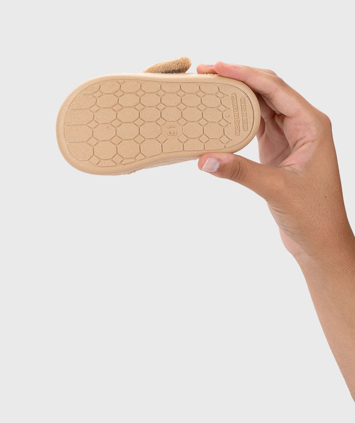 Vista inferior de uma pantufa, mostrando a sola antiderrapante em borracha, ideal para segurança extra em pisos escorregadios.