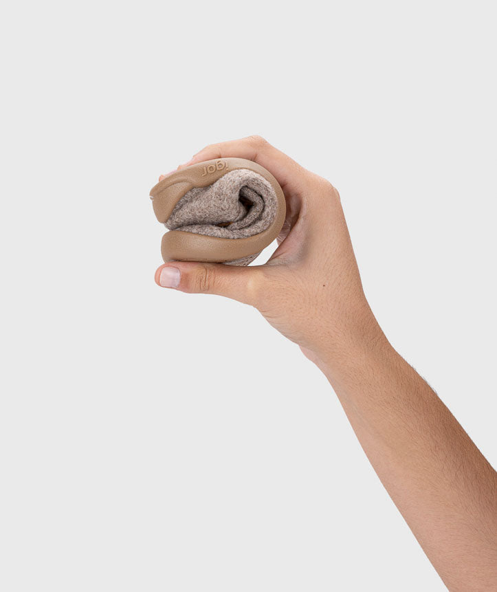 Mão a dobrar a sola da pantufa Igor Barefoot HOMIE LEON TAUPE, demonstrando a flexibilidade do calçado respeitador.