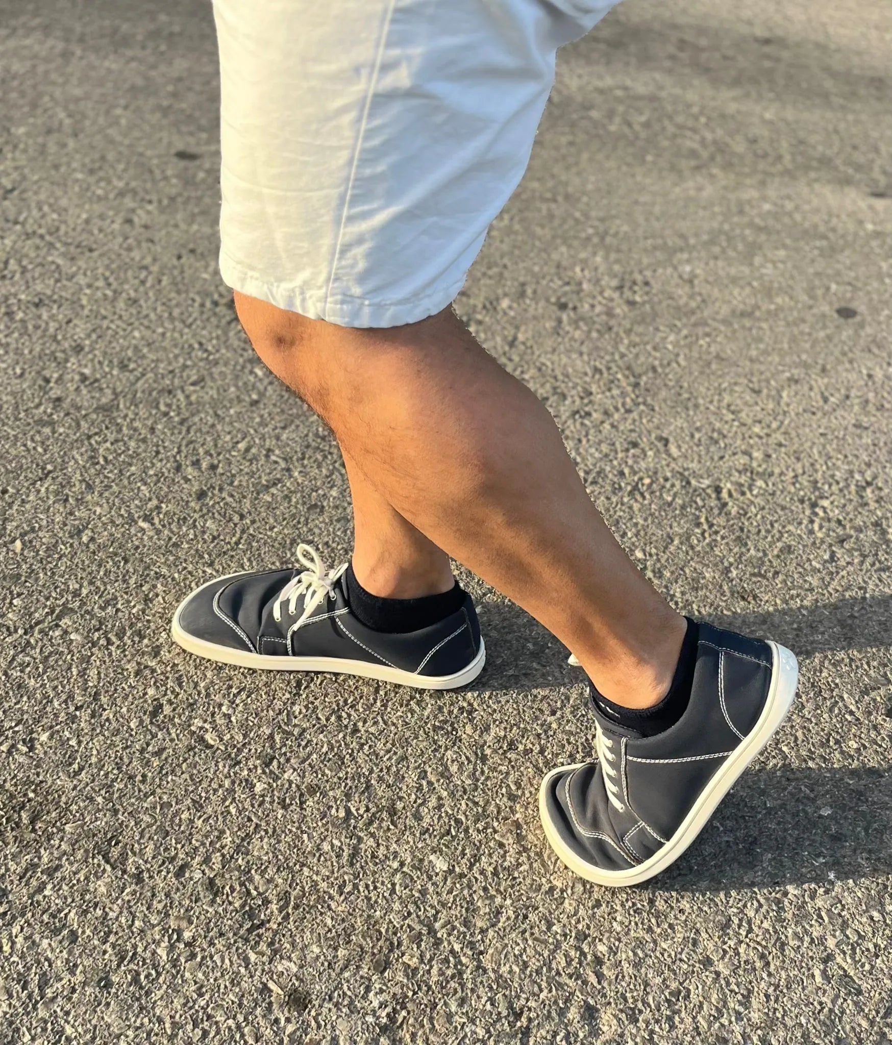 Pessoa a caminhar com o calçado barefoot adulto Mapis Noche, mostrando a flexibilidade e conforto em movimento.