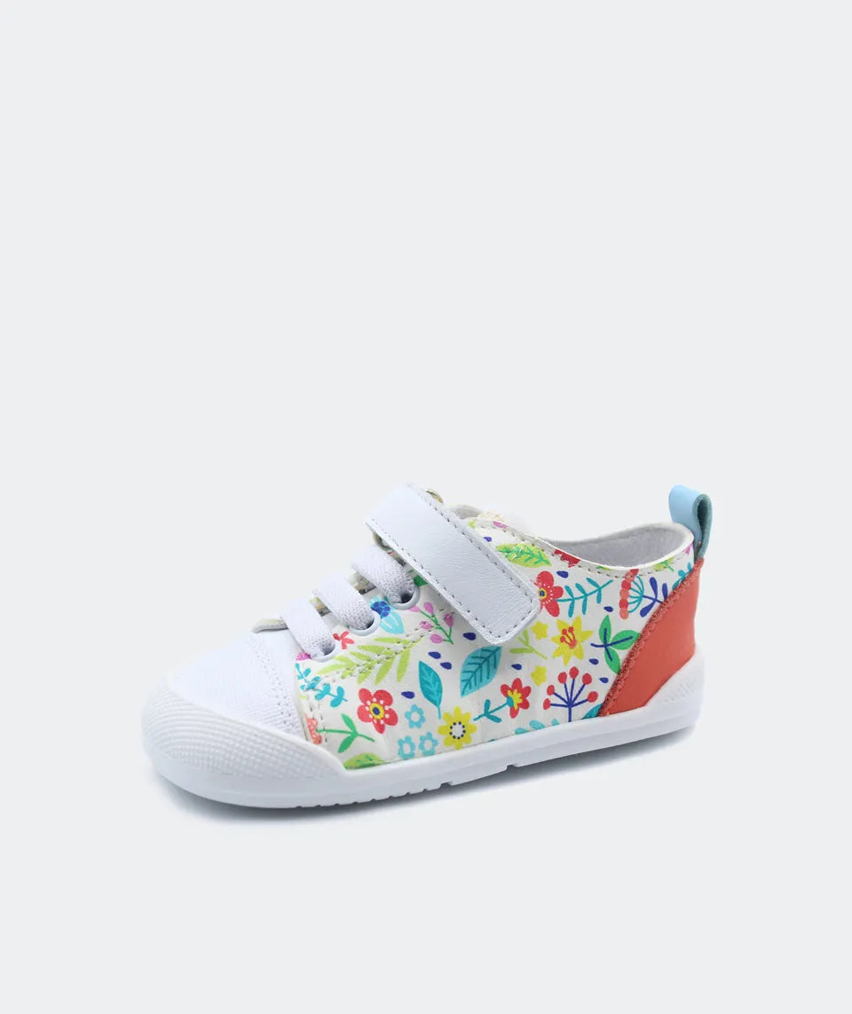 Sapatilha Blanditos by Crio's Ariel com padrão floral colorido vibrante e detalhe vermelho no calcanhar, vista lateral. Calçado Respeitador infantil Barefoot com velcro.