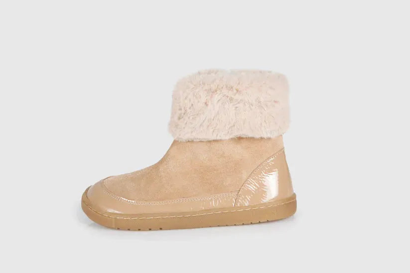 Vista lateral de uma bota infantil Blanditos Laponia Arena. Calçado respeitador barefoot bege em camurça, com forro de pelo no topo, detalhe envernizado no calcanhar e sola flexível e plana. Calçado Barefoot.