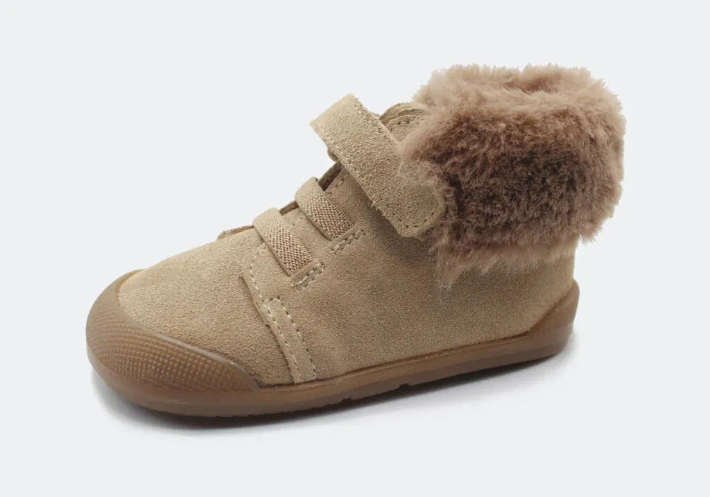 Vista lateral da Bota Sierra da Blanditos by Crio's na cor Beige. Calçado barefoot e calçado respeitador infantil em pele tipo camurça bege, com forro quente cor creme, biqueira reforçada e fecho de velcro. Calçado Barefoot.
