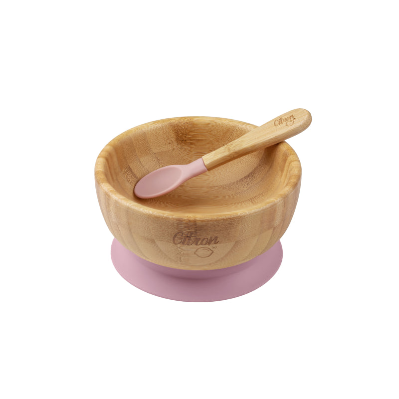 Conjunto de alimentação Citron com tigela de bambu e colher de silicone rosa, vista superior ligeiramente angulada, isolado em fundo branco.