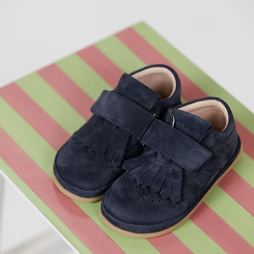 Par de sapatilhas Rooties Carneiras PiuPiu Azul Marinho em cima de um banco listrado, exibindo o design e a cor.