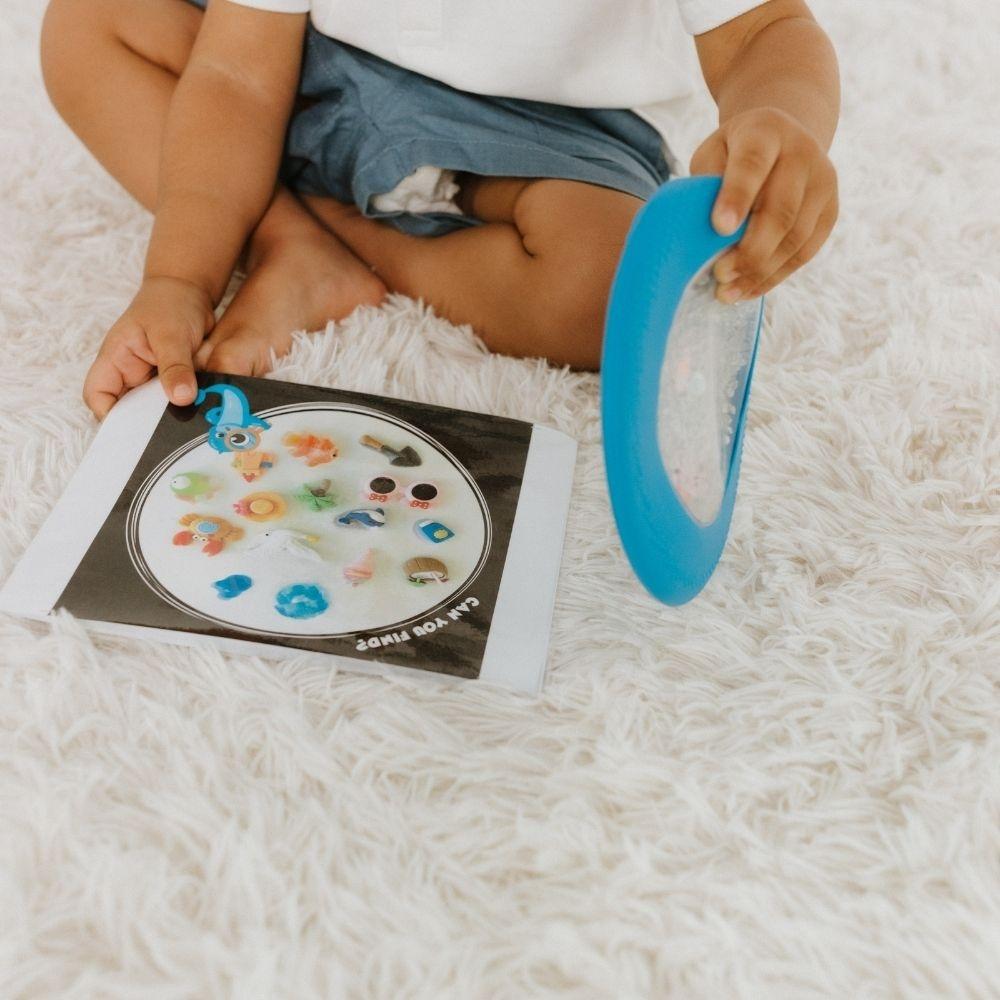 Criança a segurar a Jellystone Peekaboo Bag azul ao lado da folha de atividades.