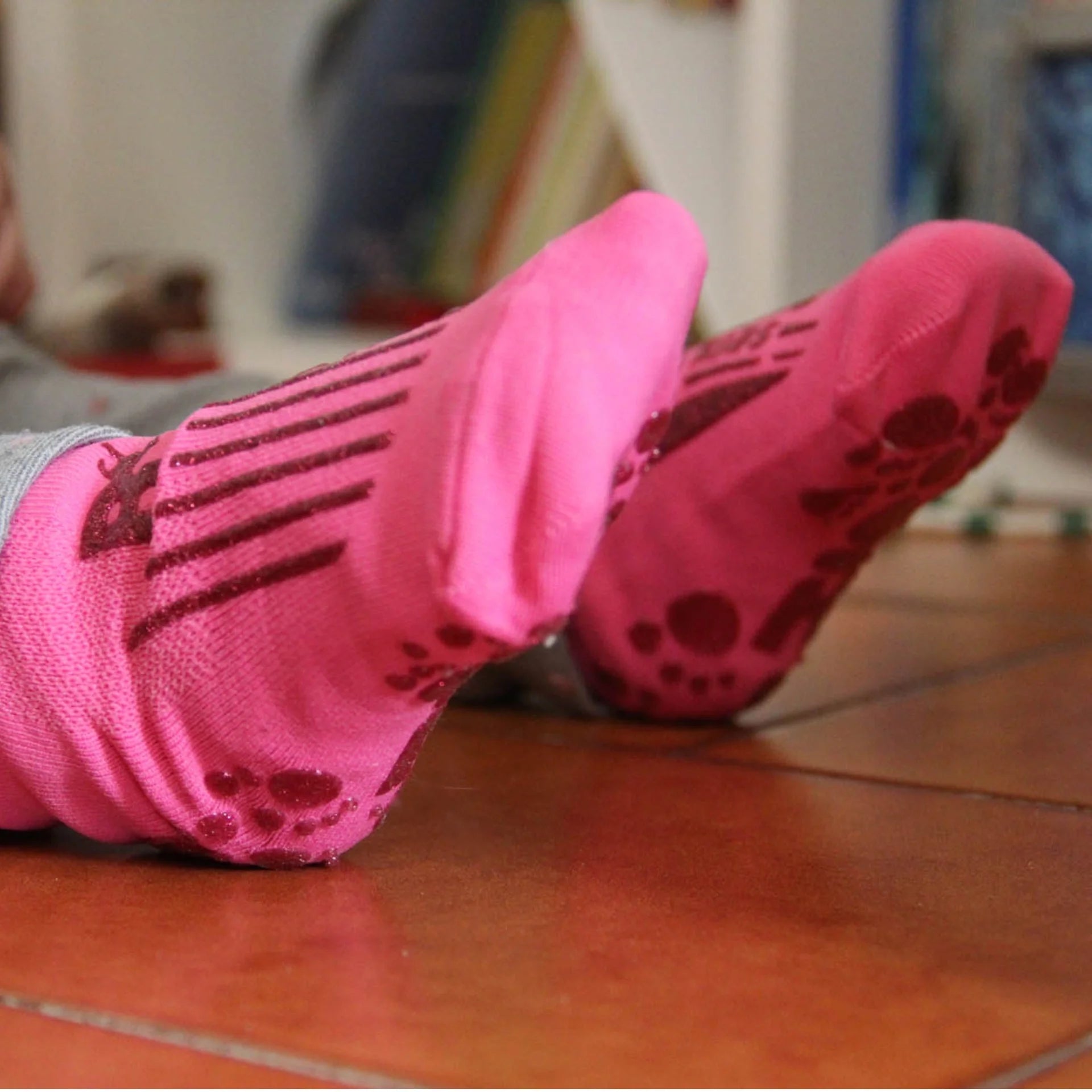 Criança a utilizar meias antiderrapantes rosa REVENGE Kids Gym, demonstrando aderência superior ao chão e conforto, ideal para brincadeiras e treinos em superfícies secas.