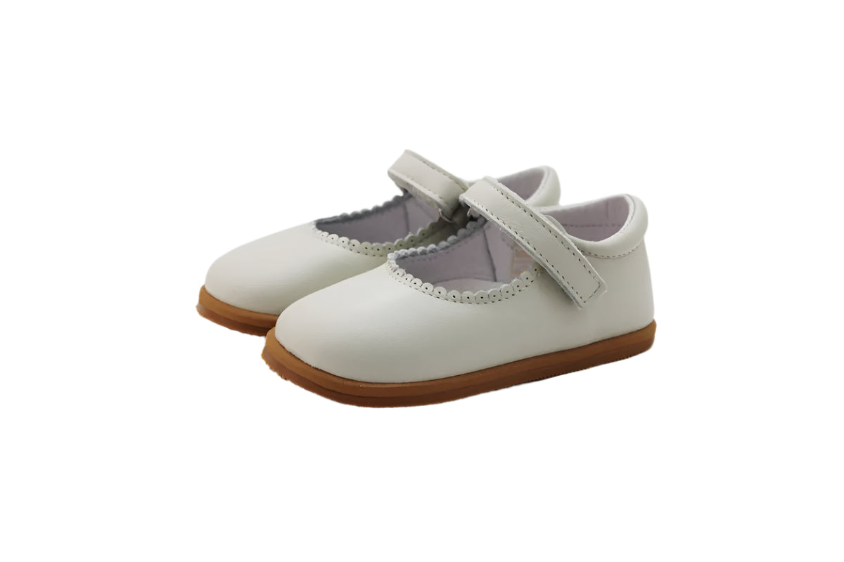 Merceditas Chloe em pele bege, com fecho em Velcro e sola antiderrapante em borracha. Modelo clássico e elegante, ideal para cerimónia.