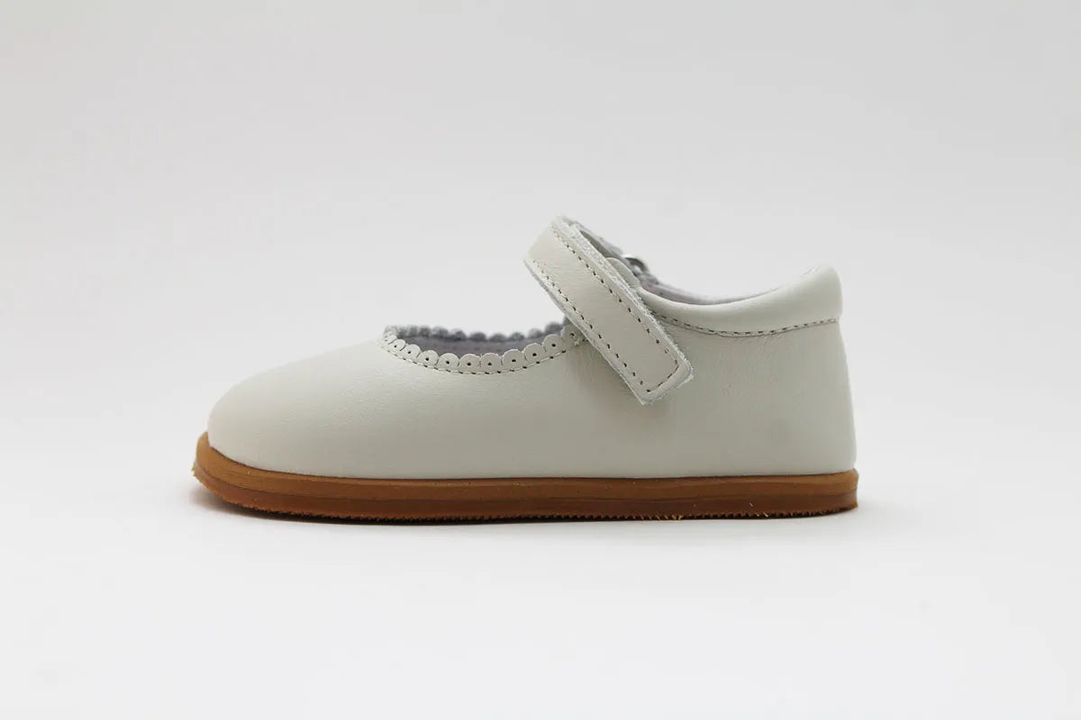 Merceditas Chloe em pele bege, vista lateral, com design anatómico e fecho em Velcro para melhor ajuste.