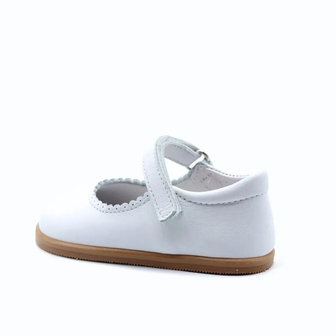 Merceditas Chloe em pele branca, vista lateral com fecho em Velcro aberto, destacando o design respeitador e a sola antiderrapante.