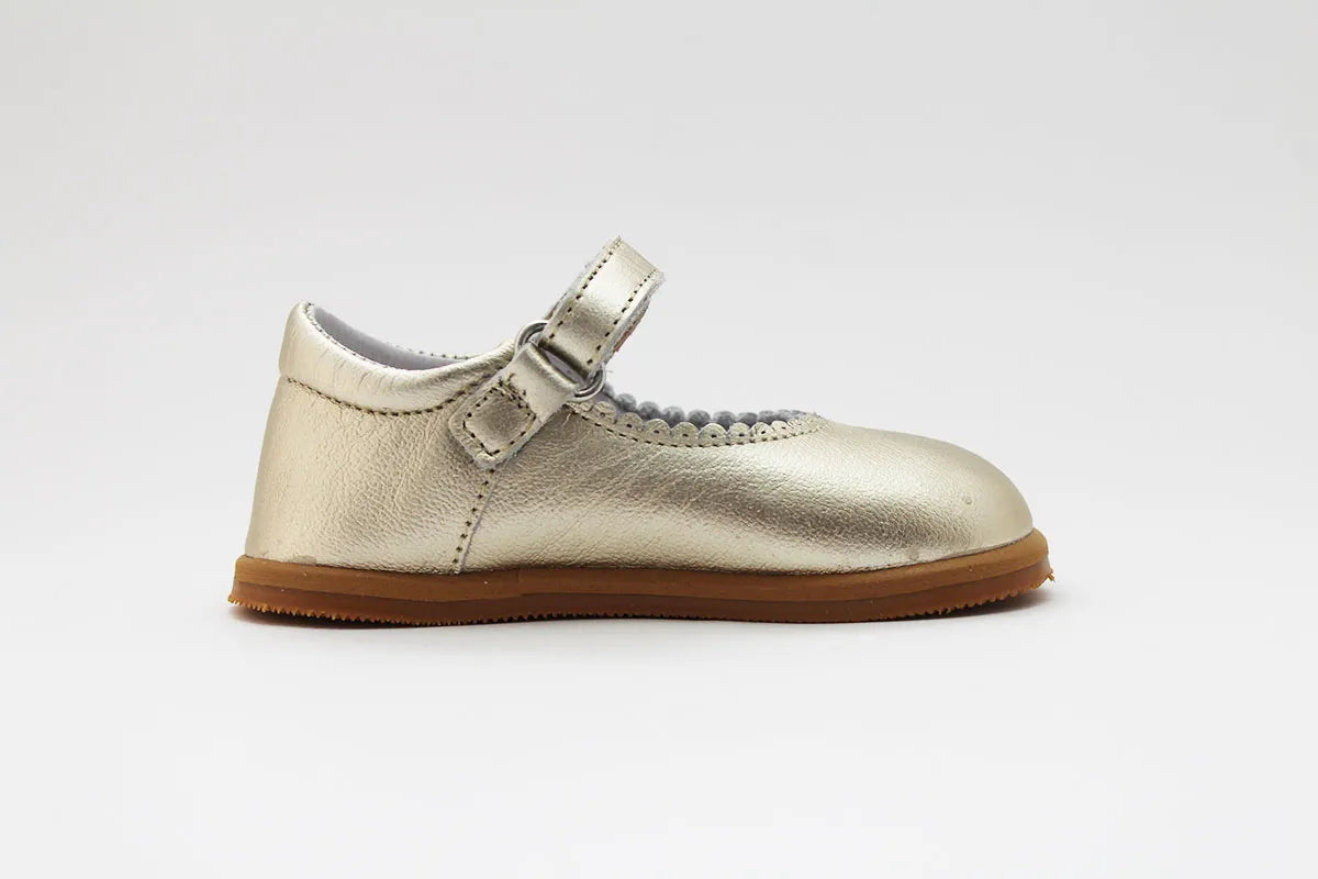 Vista lateral oposta das Merceditas Chloe em pele cor champagne, com sola antiderrapante e acabamento em pele de alta qualidade.