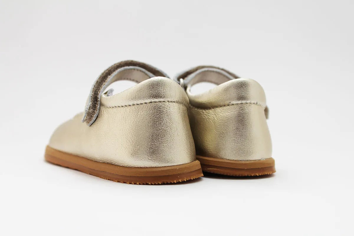 Vista traseira das Merceditas Chloe em pele cor champagne, com design simples e costura reforçada para maior durabilidade.