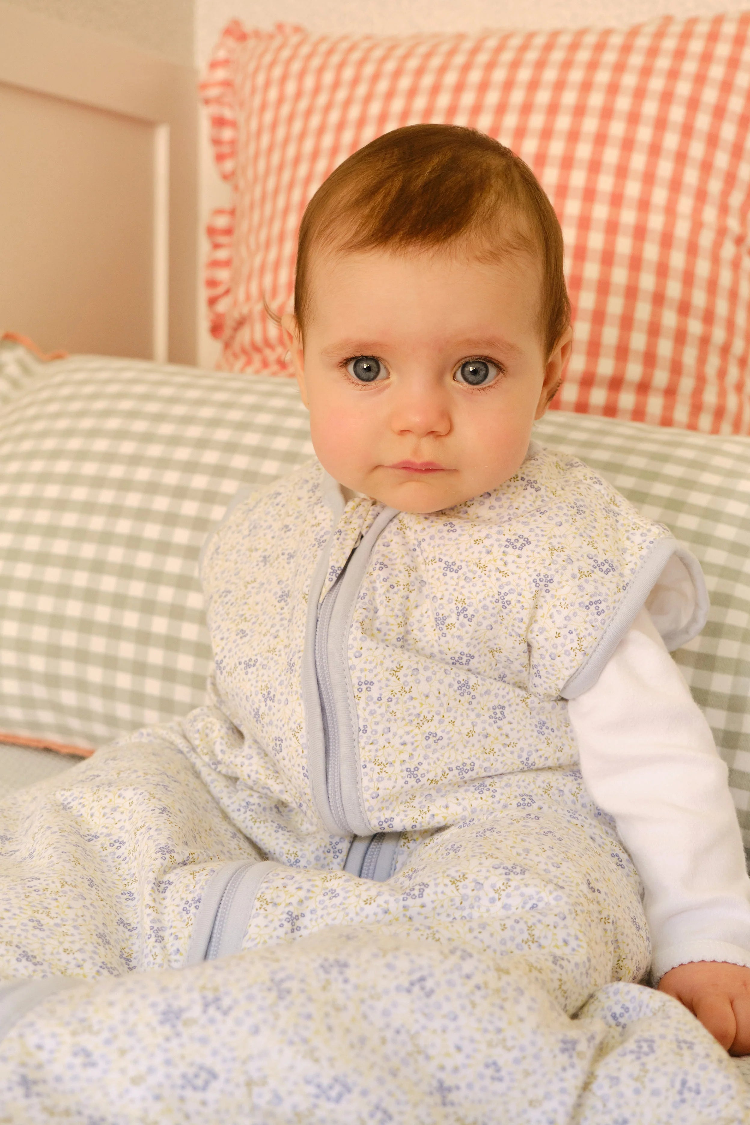 Close-up de bebé com saco de dormir MolisandCo TOG 1.0 Blue Lily, detalhe do padrão floral e fecho.