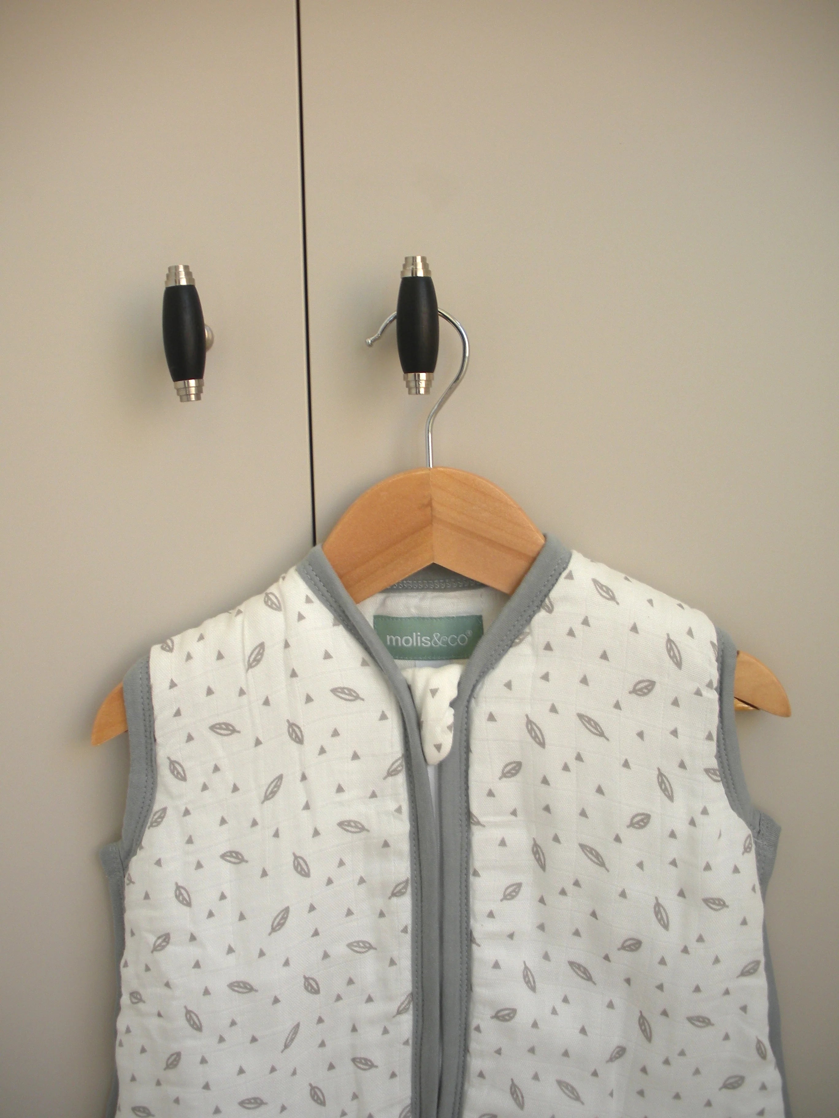 Detalhe do saco de dormir MolisandCo TOG 1.0 com padrão de folhas e etiqueta da marca visível no decote.