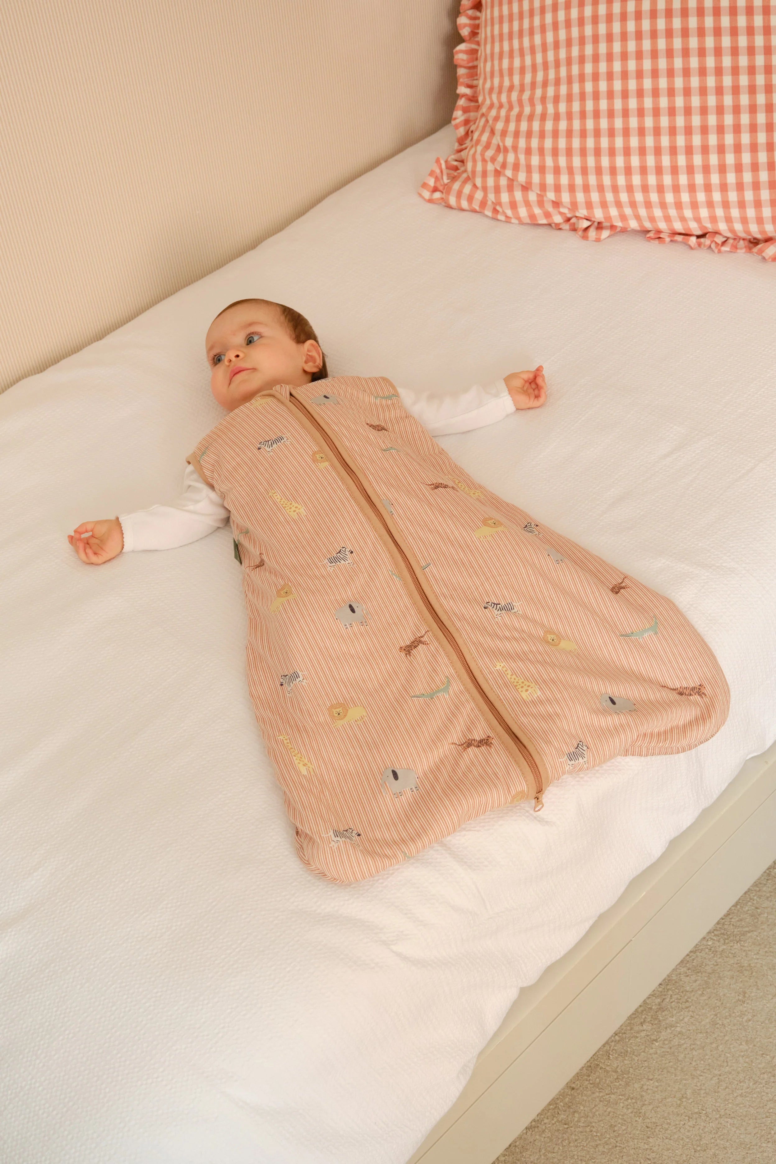 Bebé deitado na cama, a usar o saco de dormir MolisandCo TOG 1.0 Jungle, confortável e seguro.