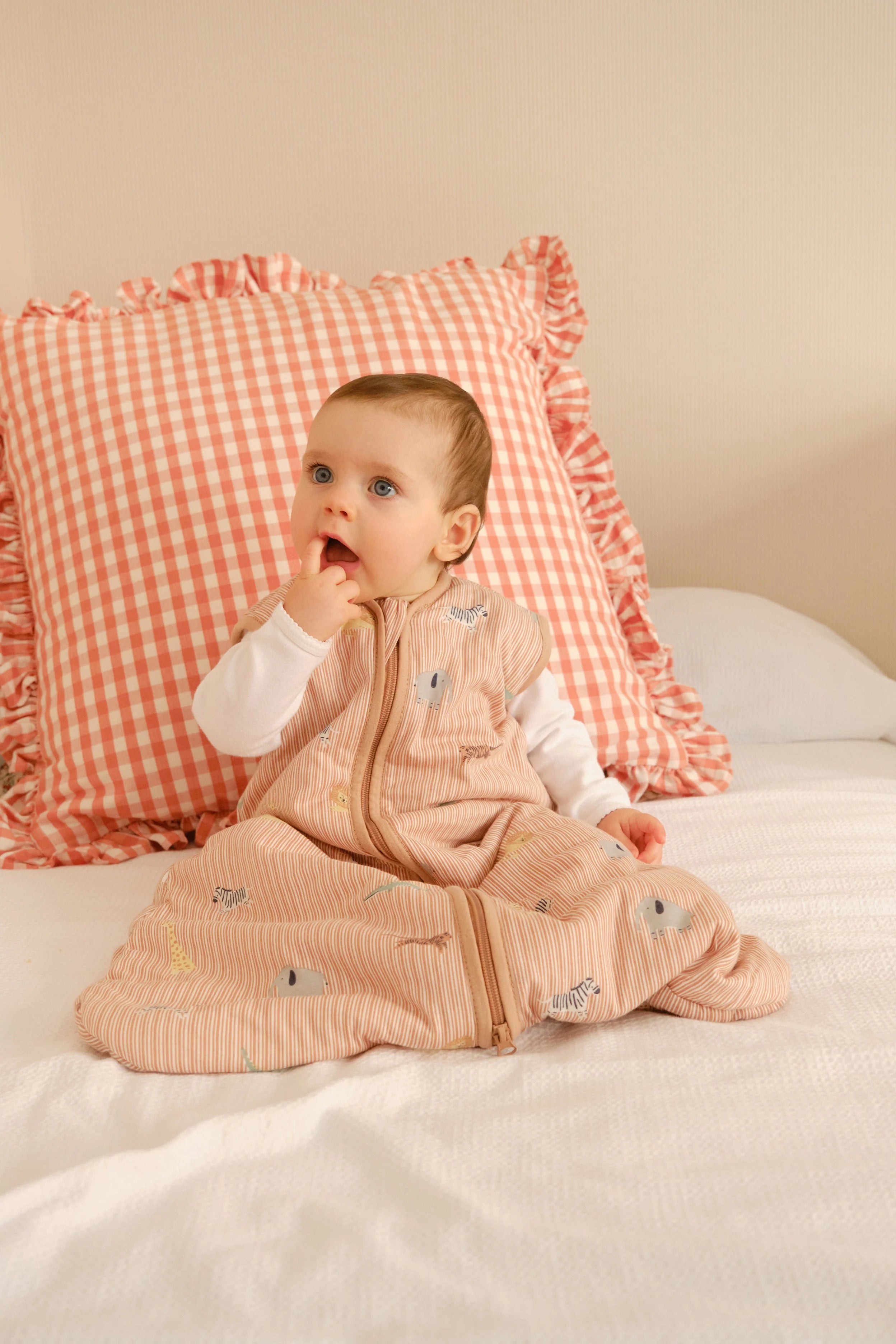 Bebé sentado na cama, a usar o saco de dormir MolisandCo TOG 1.0 Jungle, com conforto e mobilidade.