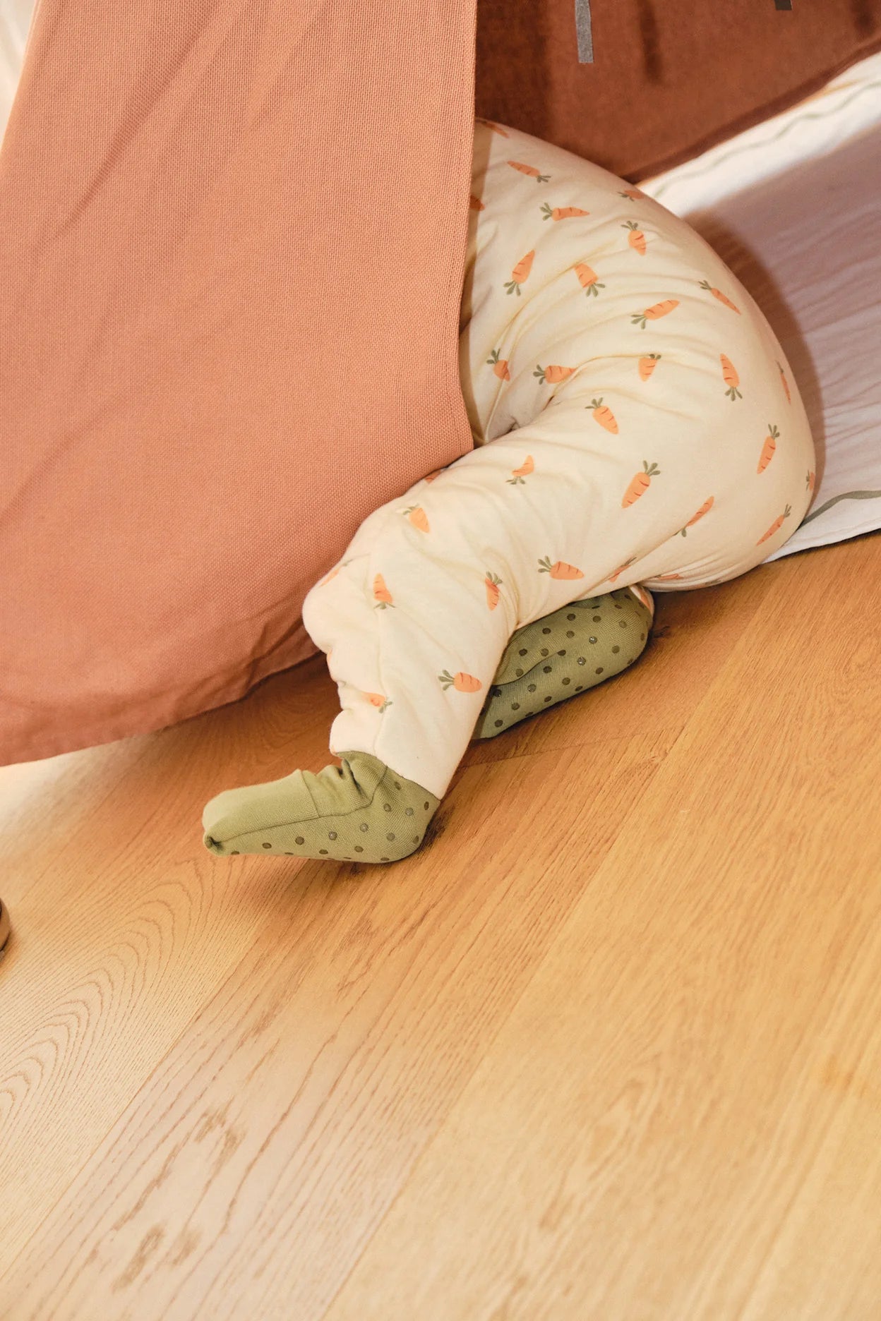 Criança a descansar no saco de dormir MolisandCo Carrots TOG 2.5, deitada confortavelmente numa manta.