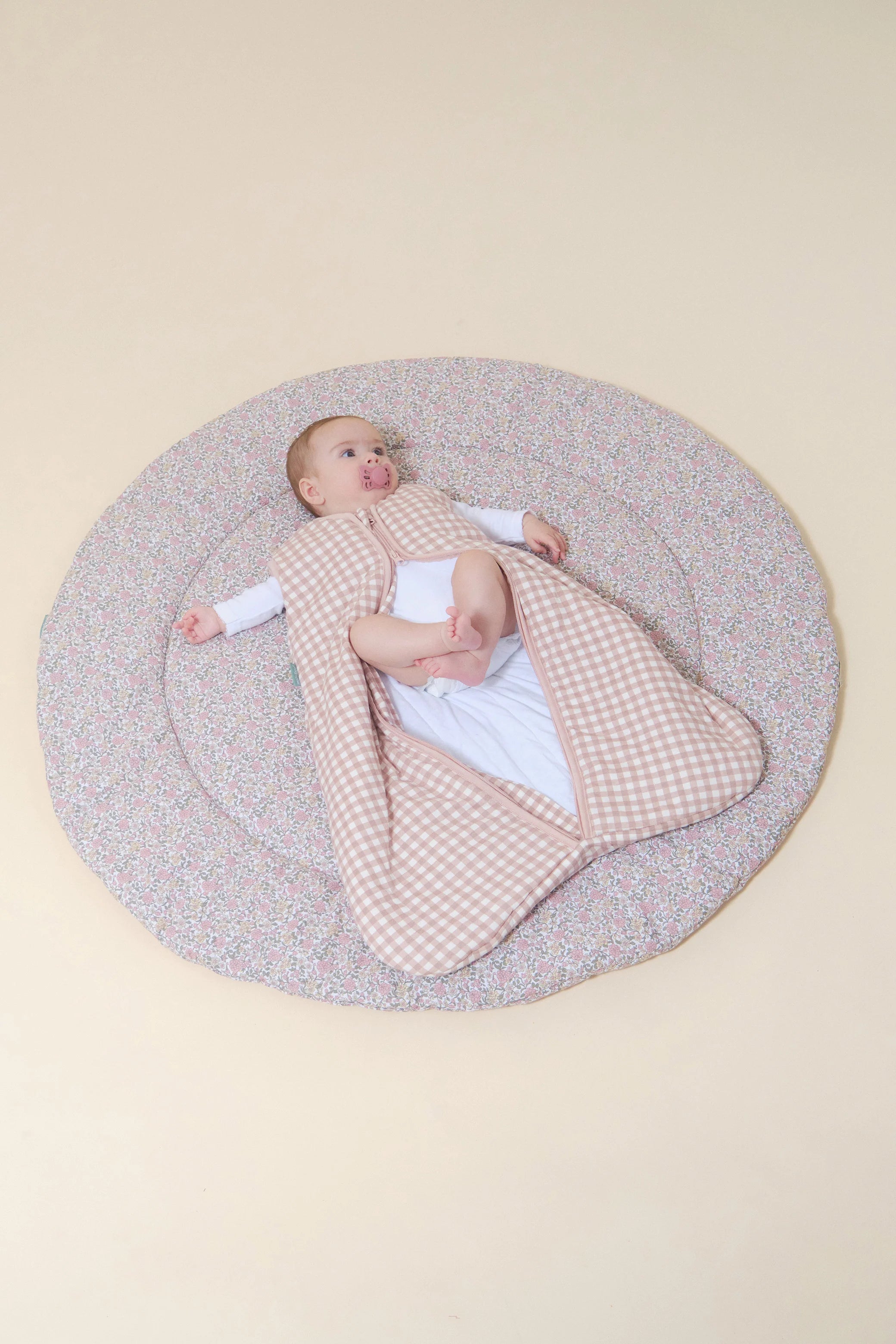 Bebé com saco de dormir MolisandCo TOG 2.5 Dusty Rose, fecho aberto, mostrando pés. Conforto e liberdade.