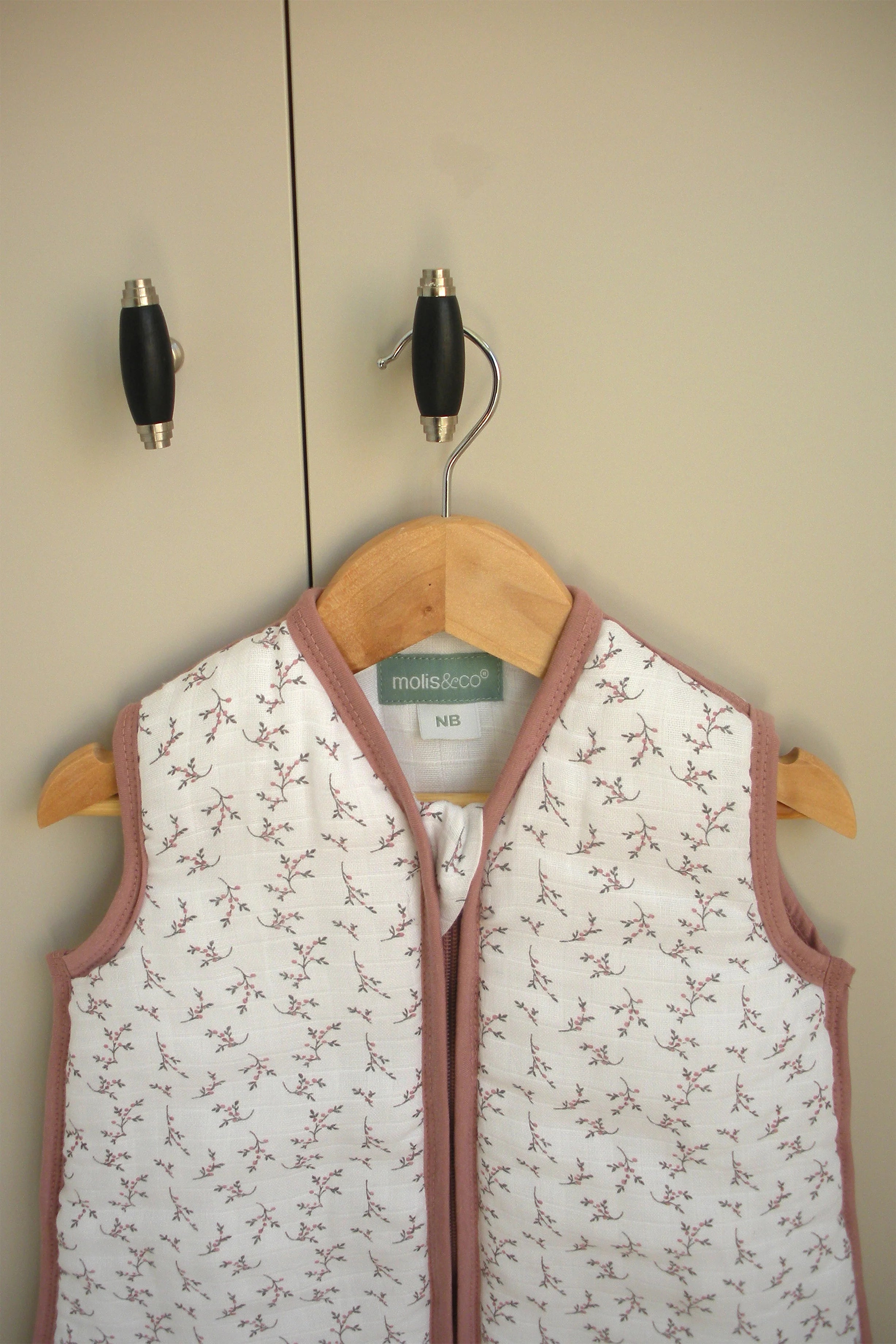 Detalhe do saco de dormir MolisandCo TOG 2.5 rosa floral, com etiqueta "NB" e marca visível.