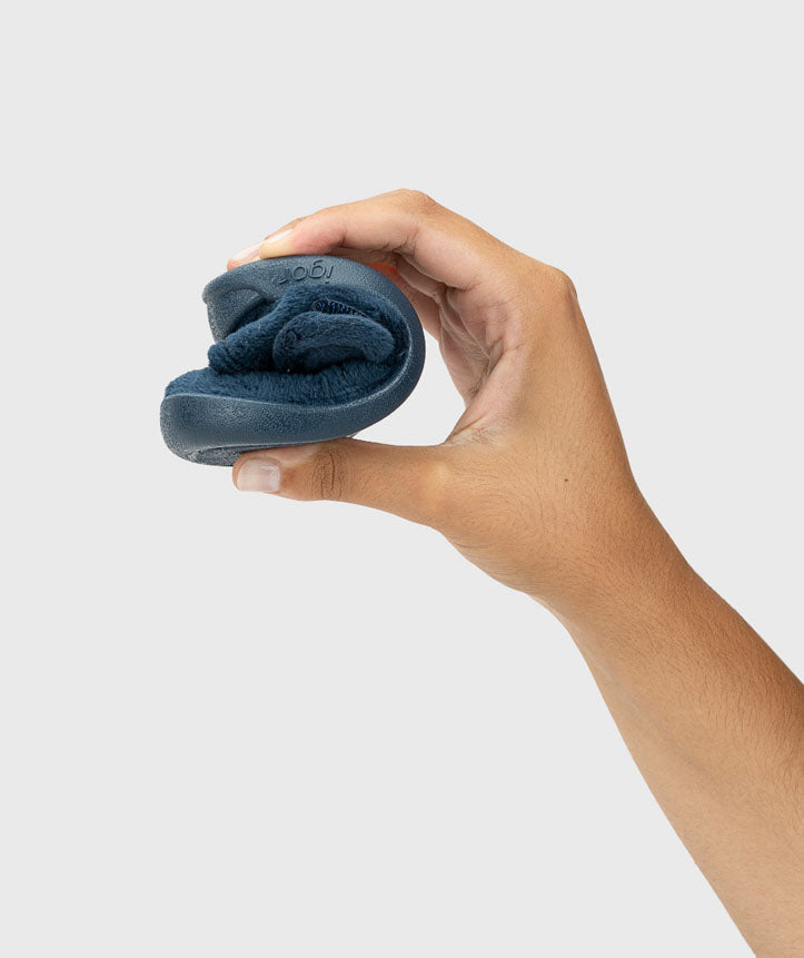 Pantufa dobrada, evidenciando a sua extrema flexibilidade, essencial para respeitar a mobilidade natural dos pés.