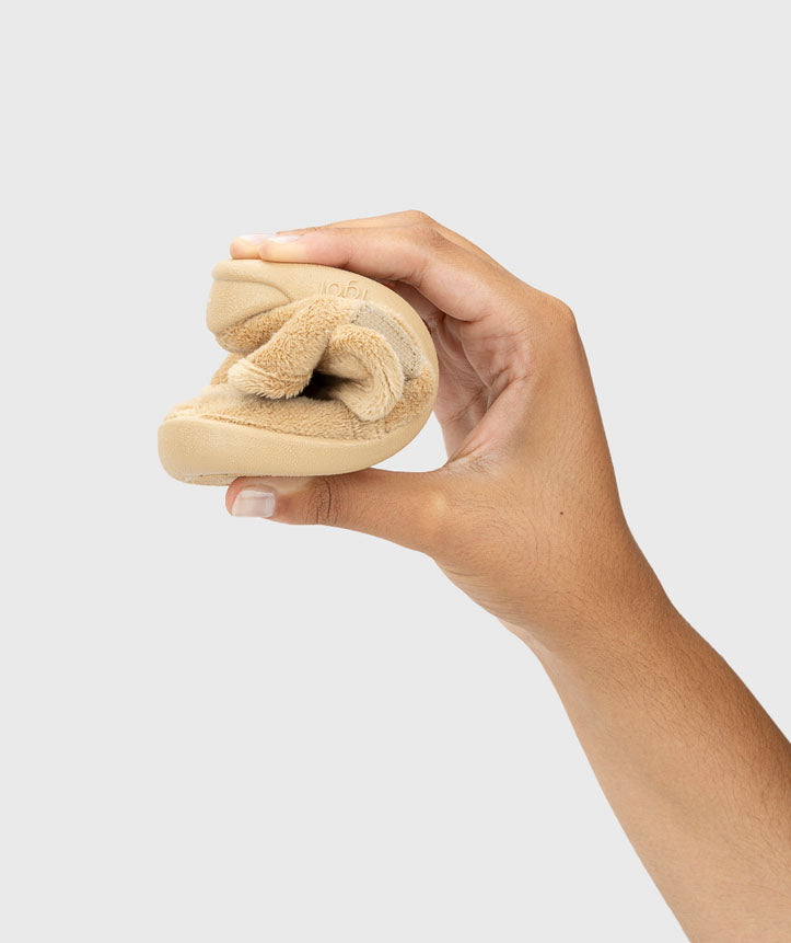 Pantufa dobrada na mão, demonstrando a sua extrema flexibilidade, essencial para um calçado respeitador e que promove o desenvolvimento saudável dos pés.