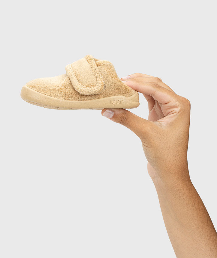 Pantufa segura na mão, mostrando a leveza e flexibilidade do material, que permite movimentos naturais e maior conforto no dia a dia.