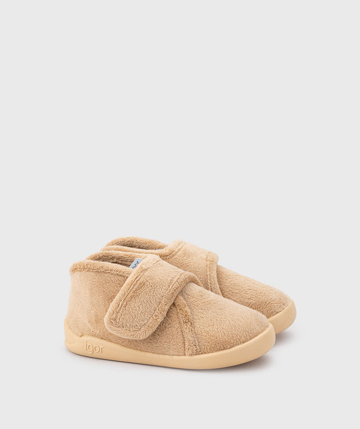 Vista lateral das pantufas barefoot bege para criança, feitas de tecido suave e respirável. Apresentam fecho em velcro e sola flexível, ideal para promover o desenvolvimento natural do pé.