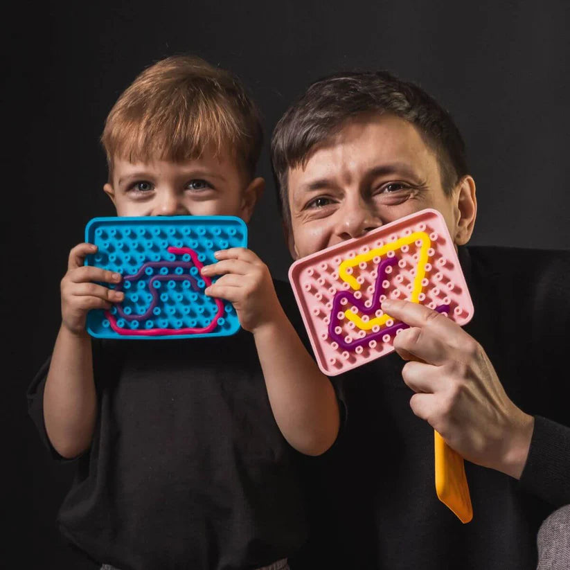 Um pai e um filho sorridentes seguram os seus Wiggly Toy Jogos Sensoriais coloridos perto dos rostos, mostrando a diversão e a interação que o brinquedo proporciona.