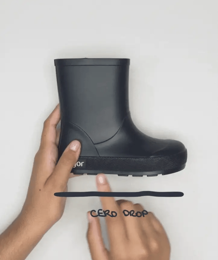 Mão a segurar uma galocha Igor Yogi MARINO azul-marinho, destacando a leveza e o design minimalista.