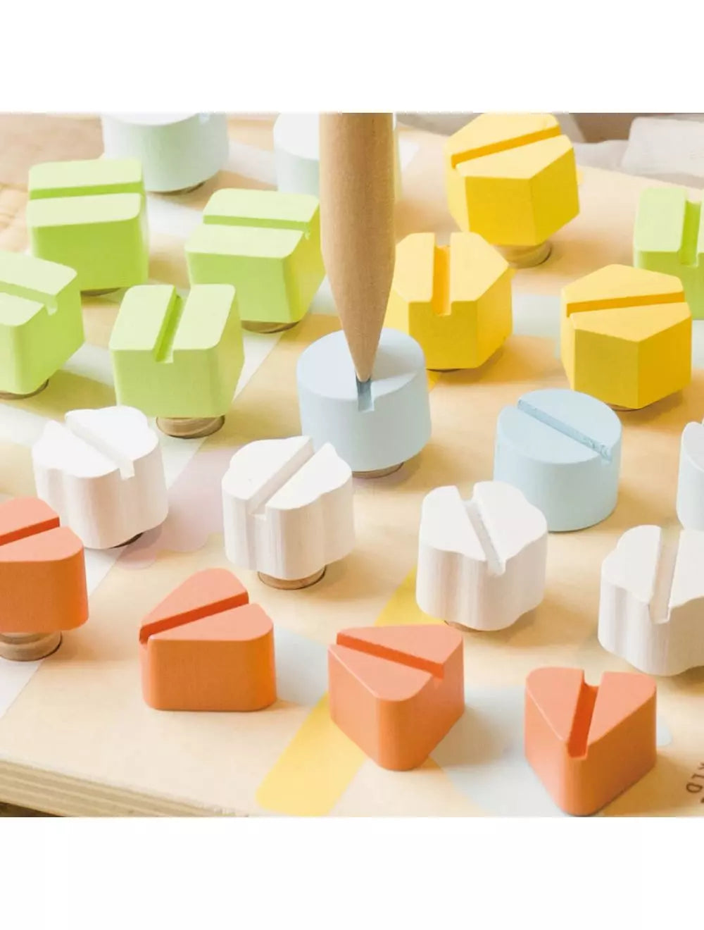 Close-up dos parafusos coloridos da tábua de madeira Classic World, mostrando detalhes das formas e cores.