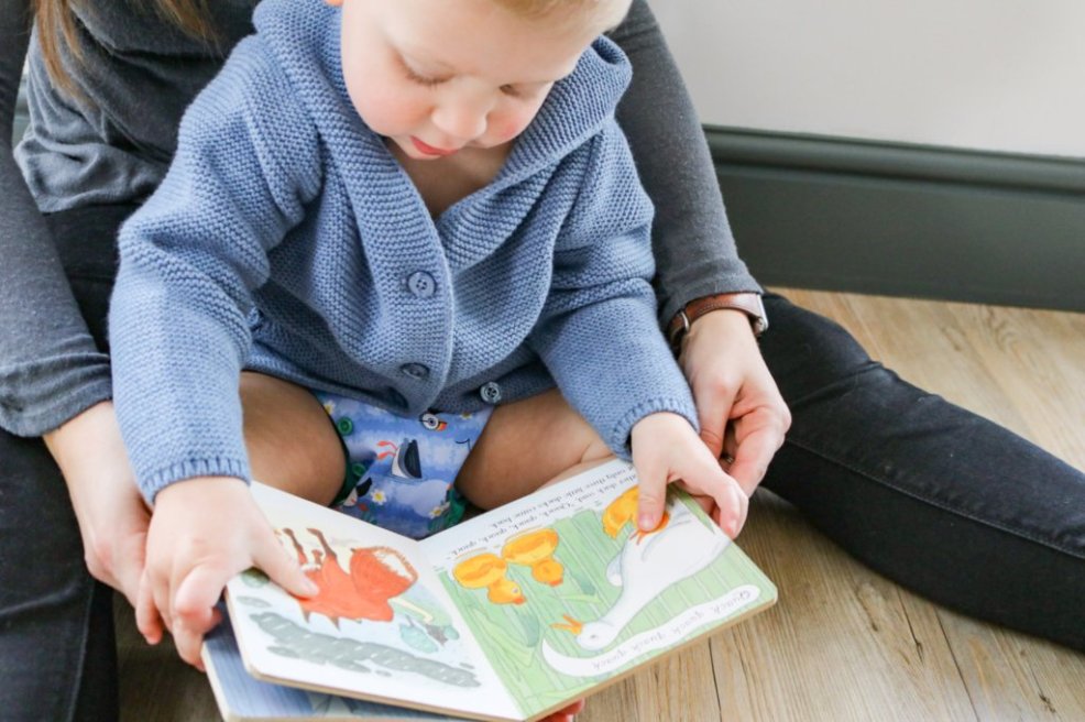 Bebé a usar a fralda reutilizável Close Pop-in, a ler um livro.