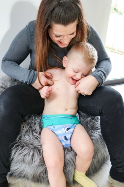 Bebé a usar a fralda reutilizável Close Pop-in, a brincar com a mãe.