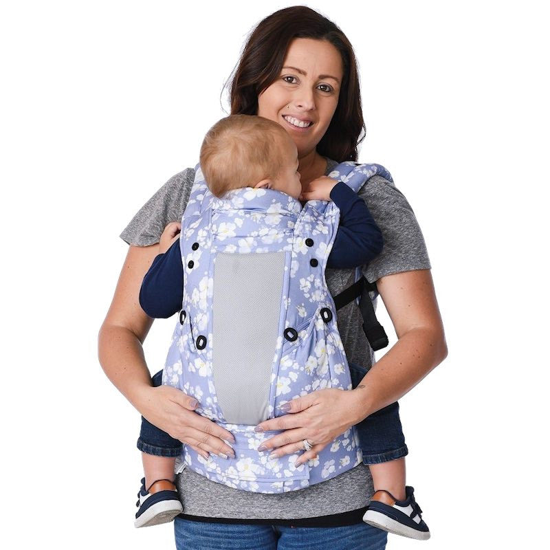 Mãe usando porta-bebê floral azul e branco Gotu, mostrando conforto e praticidade do babywearing. Aluguer de porta-bebés.