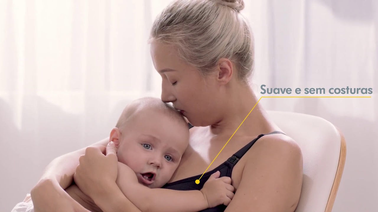 Mãe a amamentar o seu bebé, usando um sutiã Medela Comfy (cor escura), destacando o conforto e a praticidade.