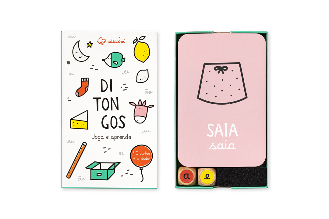 Cartas e dados do jogo Ditongos Joga e Aprende dispostos sobre a mesa