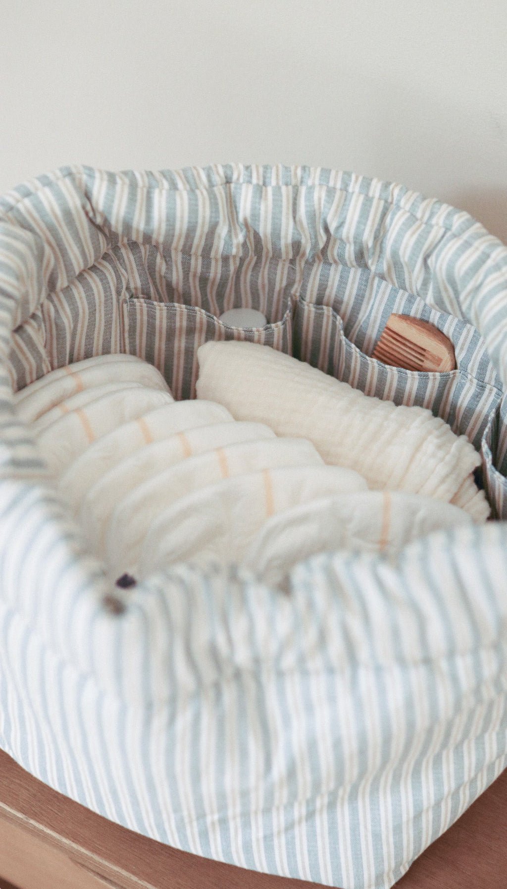 Organizador de mala de bebé MolisandCo Blue Stripes em ambiente de casa, ao lado dos complementos de um dia com o bebé