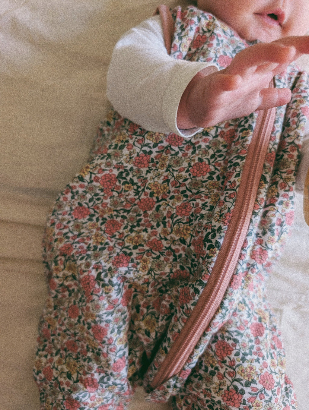 Pijama manta MolisandCo TOG 1.0 com pés e meias antiderrapantes na cor Peony, vestido por uma criança