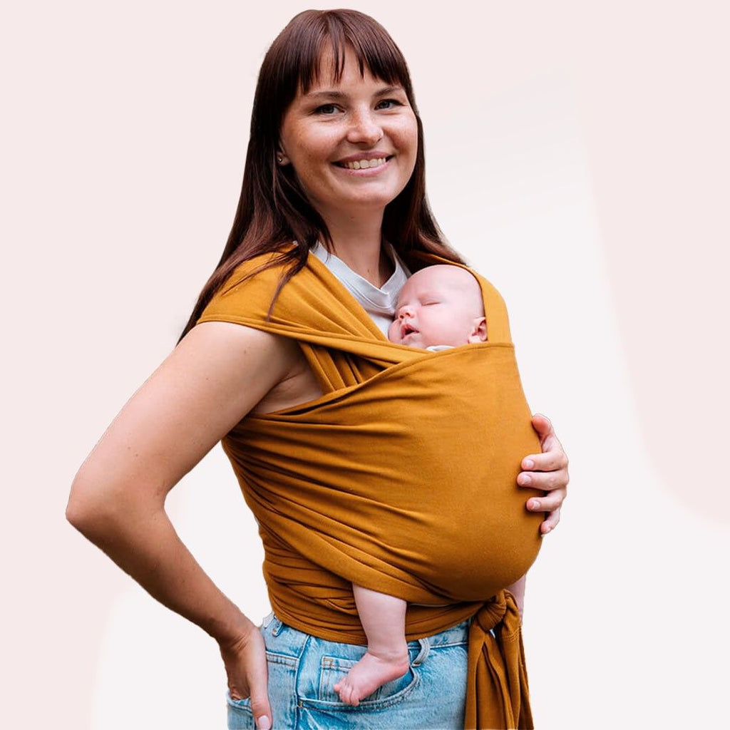 Fular elástico de modal Love and Carry na cor Masala, com o bebé ao colo na posição em M