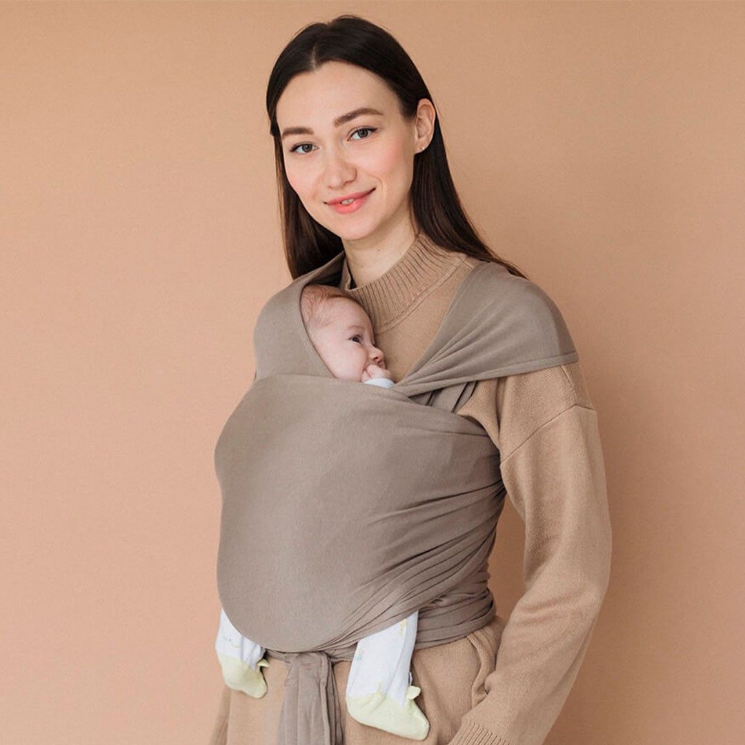Fular elástico de modal Love and Carry na cor Muscat, com o bebé ao colo na posição em M
