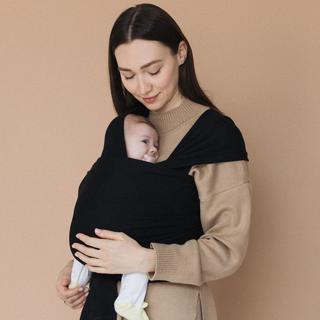 Fular elástico de modal Love and Carry na cor Noir, com o bebé ao colo na posição em M