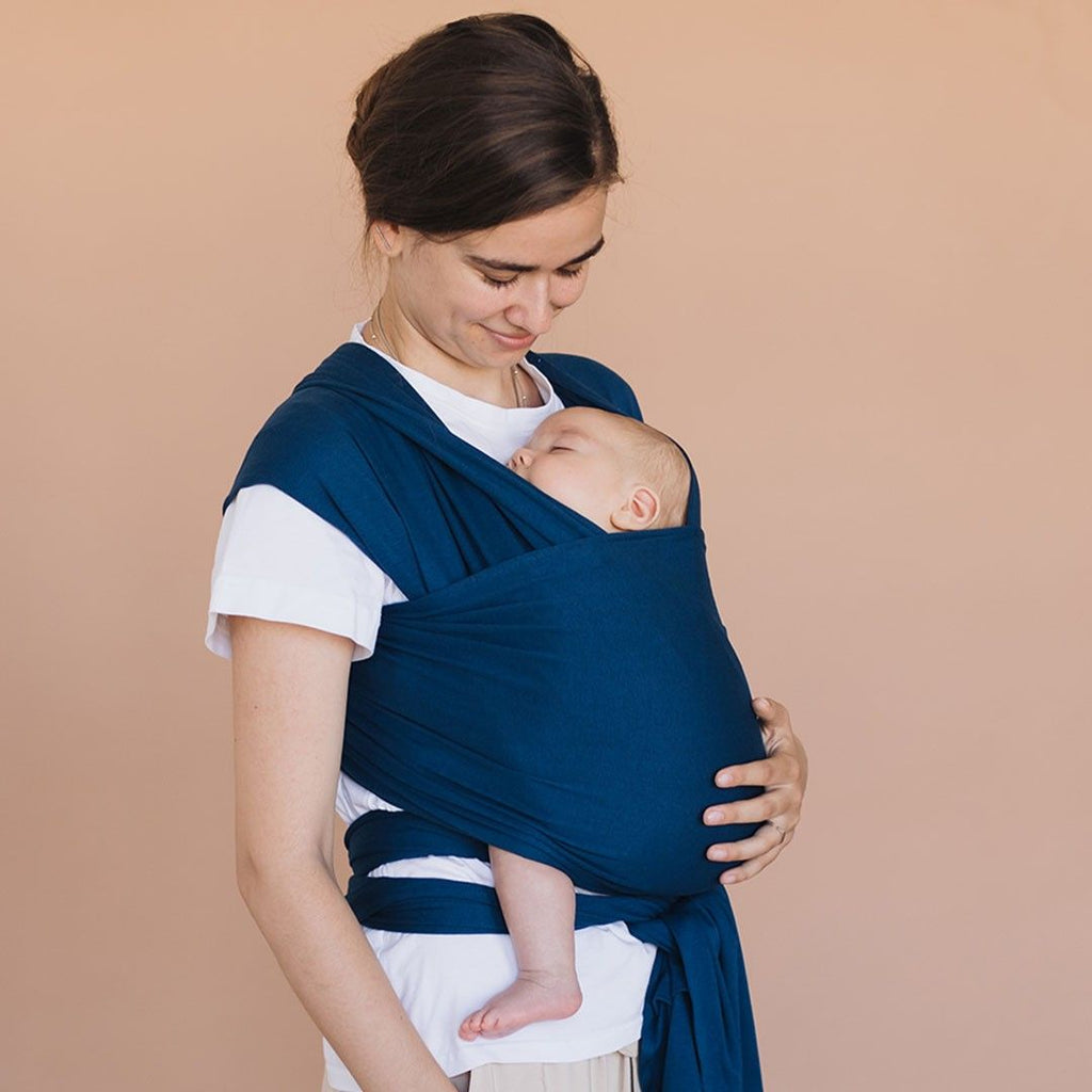 Fular elástico de modal Love and Carry na cor Poseidon, com o bebé ao colo na posição em M