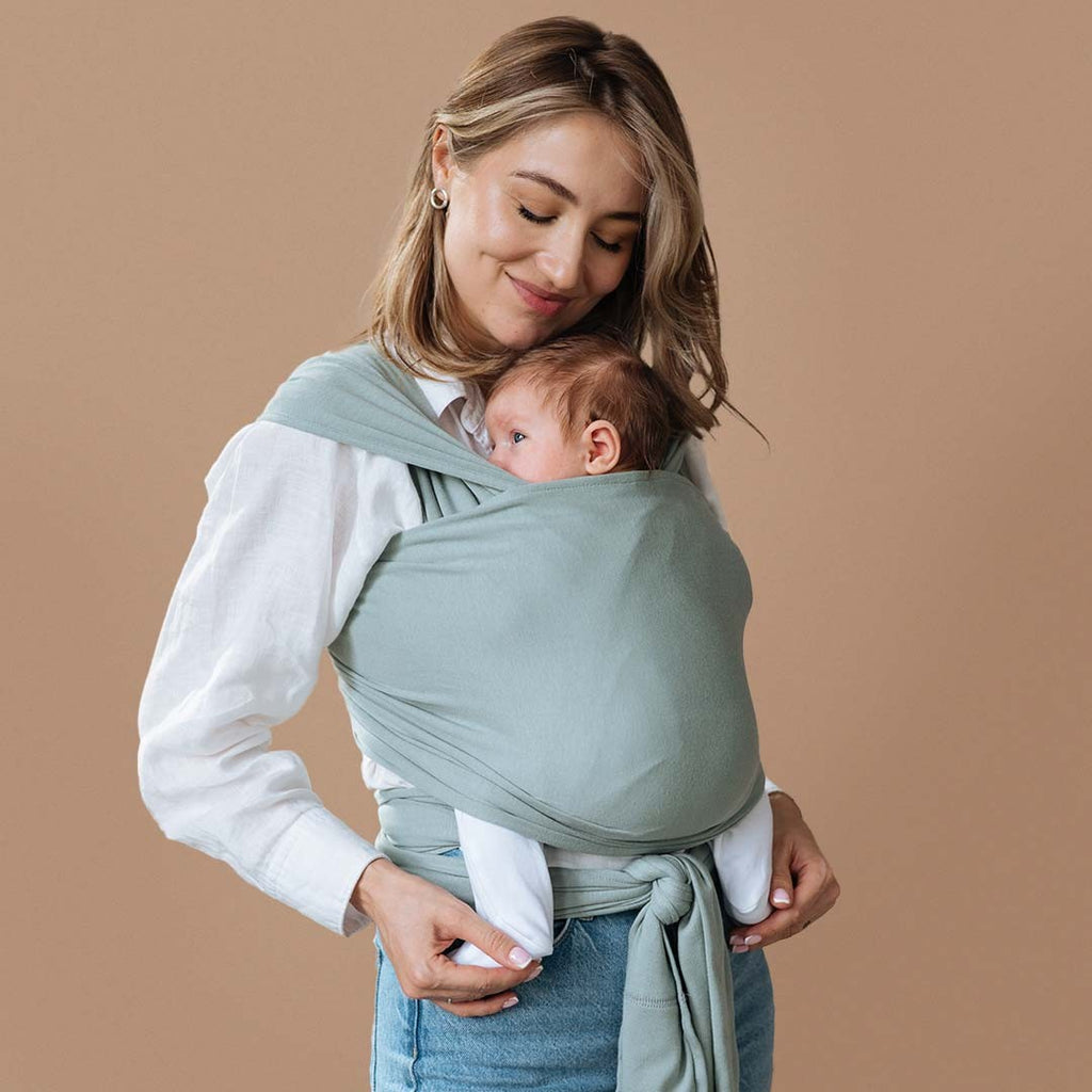 Fular elástico de modal Love and Carry na cor Sage, com o bebé ao colo na posição em M