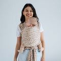 Fular elástico de modal Love and Carry na cor Prairie, com o bebé ao colo na posição em M