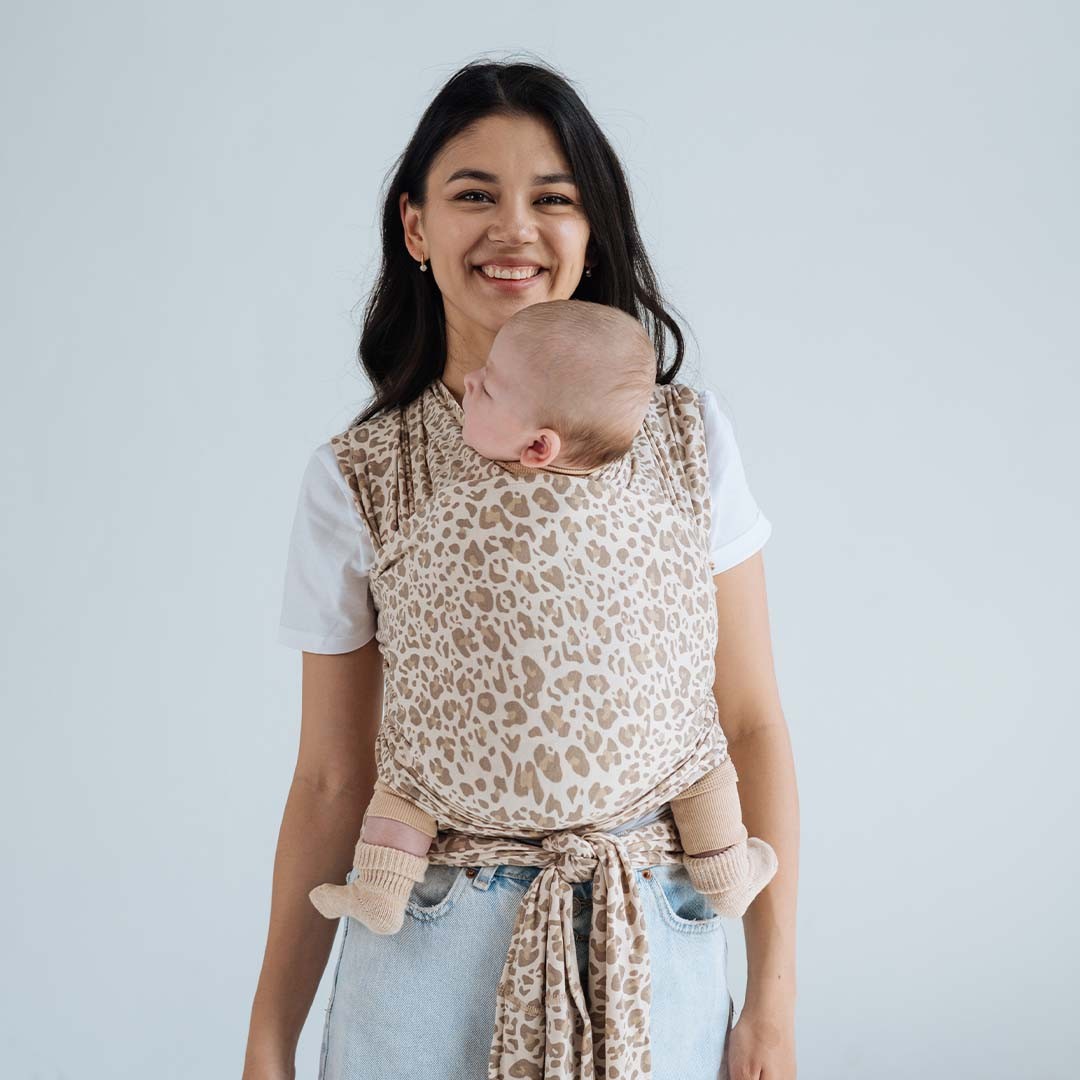 Fular elástico de modal Love and Carry na cor Prairie, com o bebé ao colo na posição em M