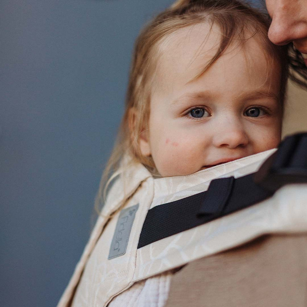 Fidella Fusion ToddlerSize Seashell Sand em uso, com a criança na posição em M